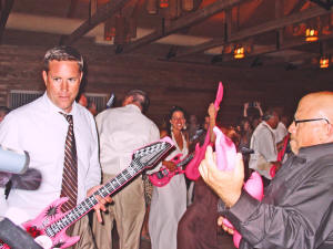Playing air guitar at a lively wedding reception in a log cabin