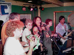 Click for enlarged view.  Partiers join the band on stage.